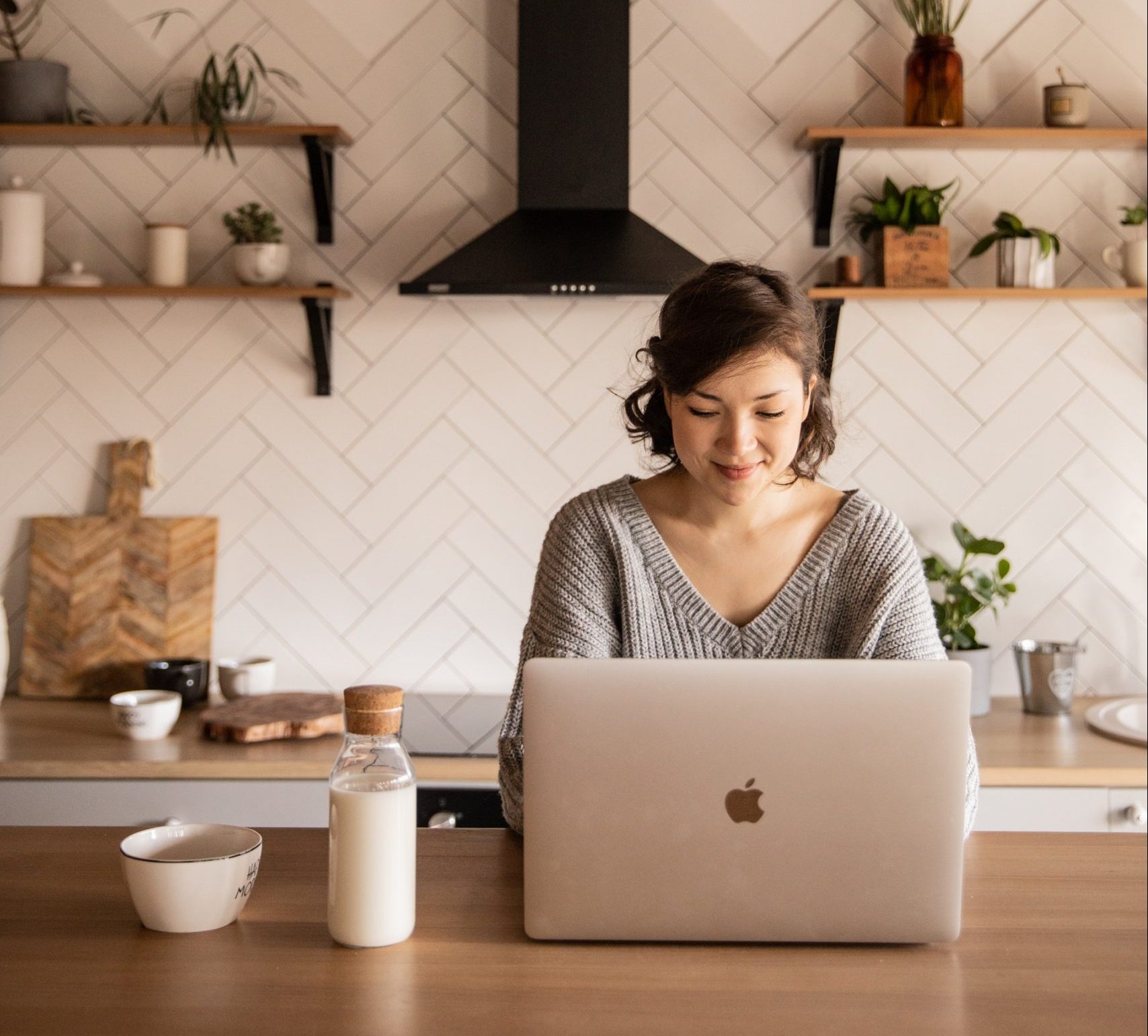 Woman shopping on laptop in contemporary kitchen
